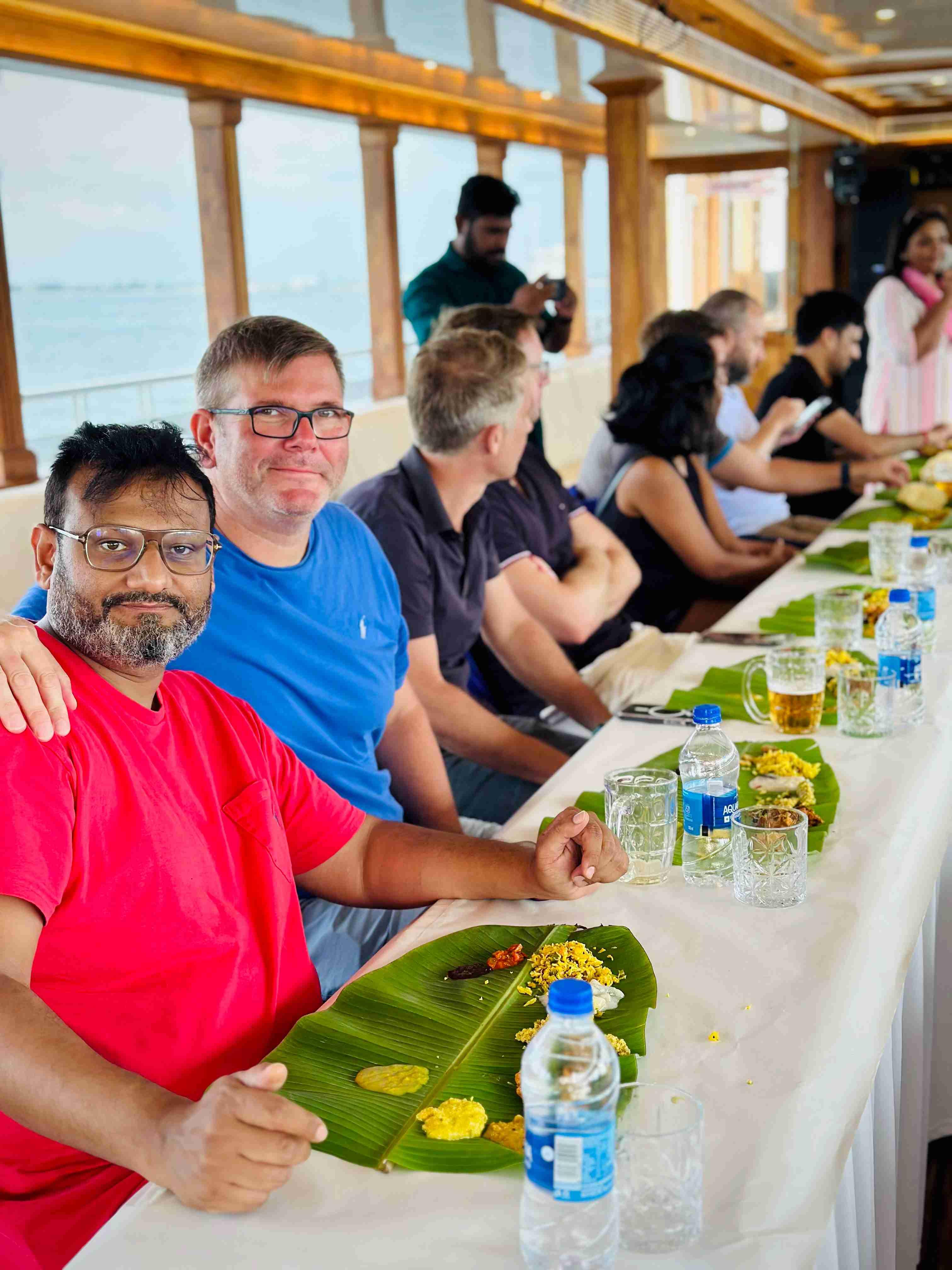 Team enjoying traditional Kerala meal aboard Minar Cruise during a scenic Arabian Sea voyage