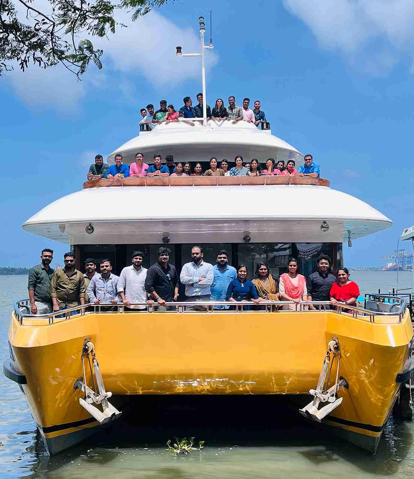 People gathering on Minar Cruise for a scenic sea voyage, white and yellow catamaran in Kochi