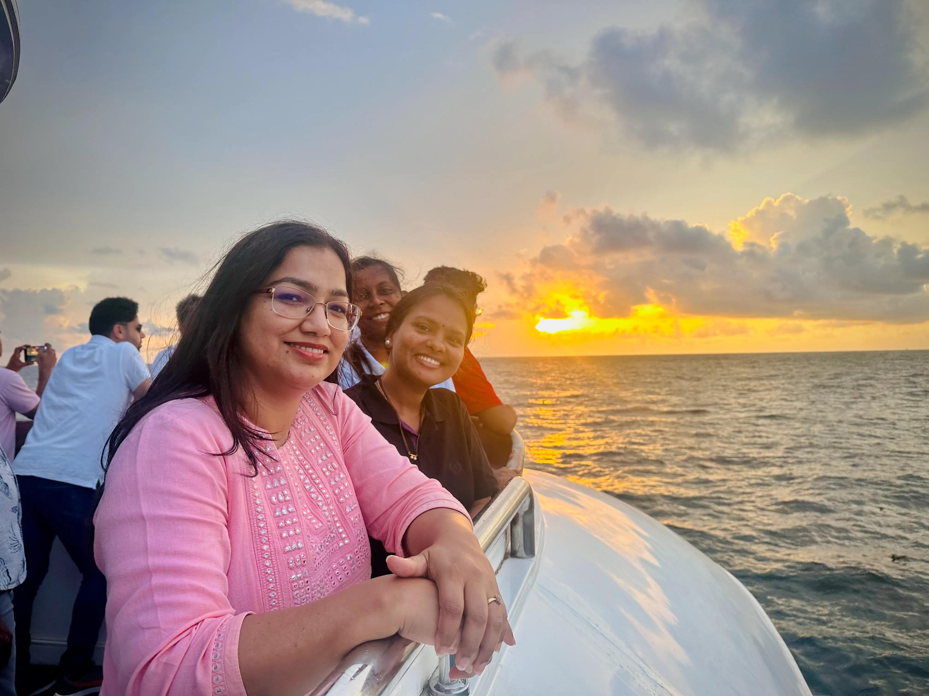 Group of women smiling aboard Minar Cruise, watching the sunset over the Arabian Sea on a scenic evening trip