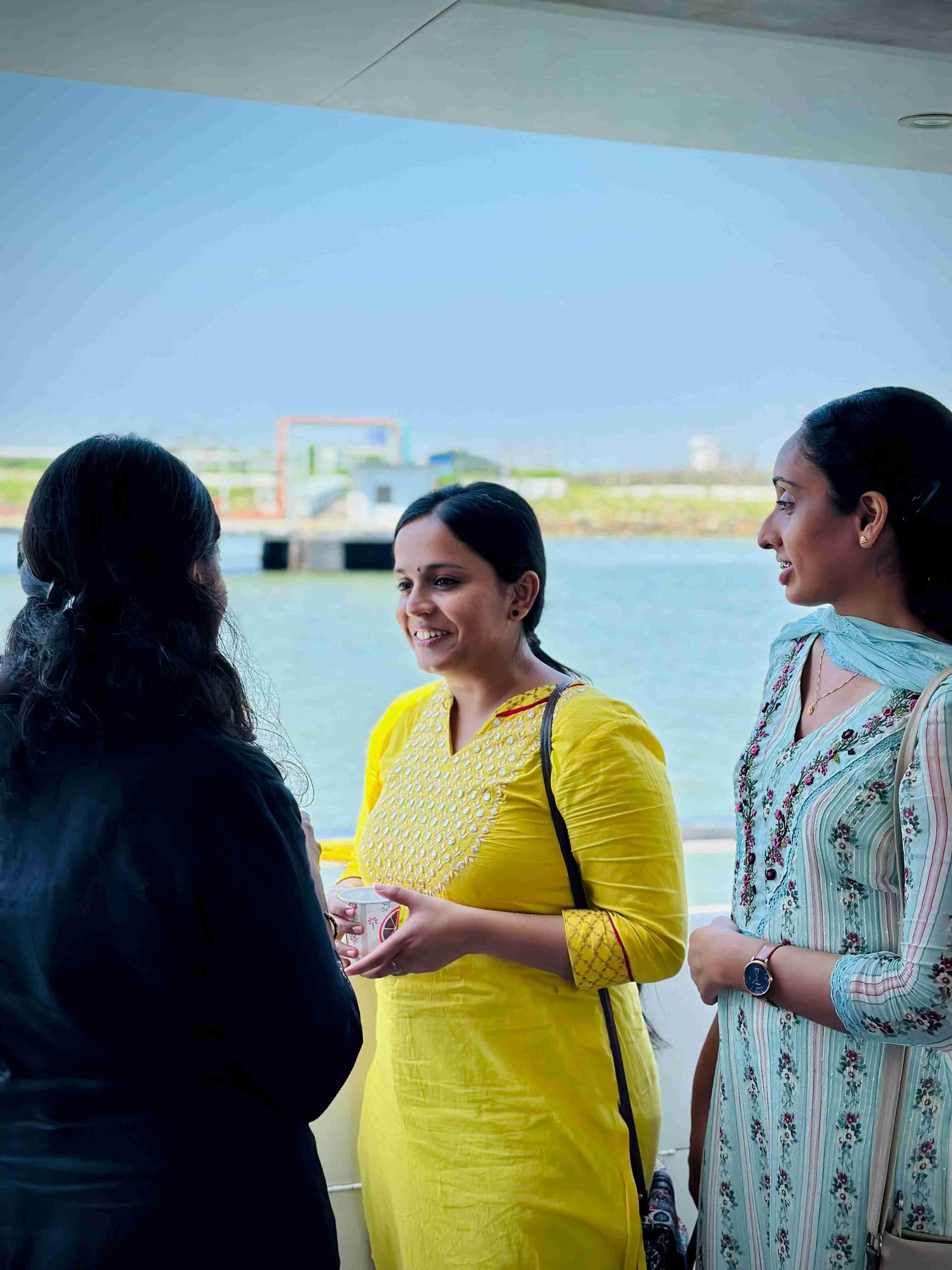 Guests enjoying a warm conversation on the deck of Minar Cruise, overlooking the Arabian Sea